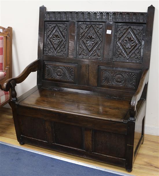 A 17th century style oak monks bench, W.109cm